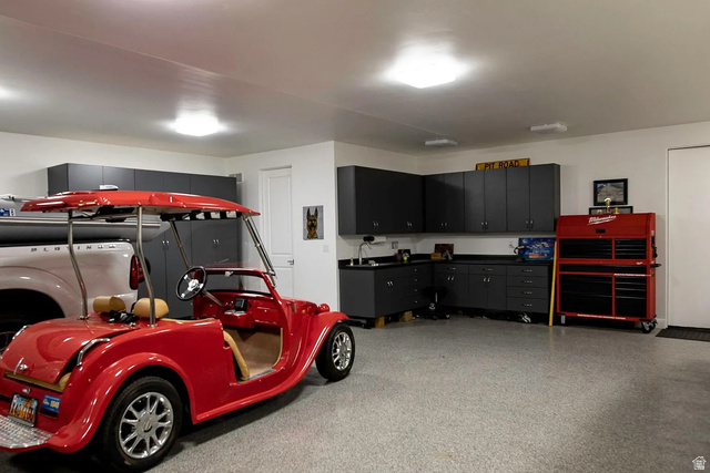 1500 Split Rock, Unit 150 Ivins, UT 84738 - Photo 14 of 14 Spacious garage featuring a durable epoxy floor, ample recessed lighting, extensive built-in dark cabinetry, and a dedicated workspace with a sink
