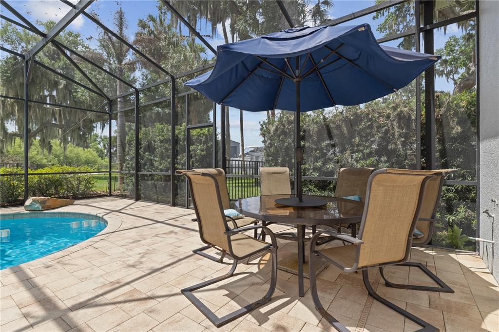 16948 Deer Island Road Tavares, FL 32778 - Photo 51 of 67 a view of a patio with table and chairs under an umbrella