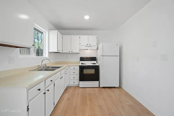 a kitchen with granite countertop white cabinets and white appliances