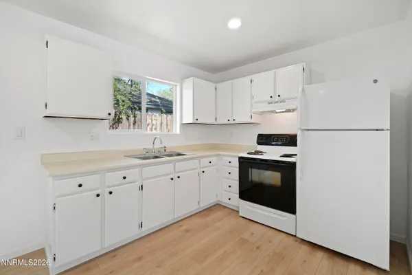 a kitchen with granite countertop white cabinets and white appliances