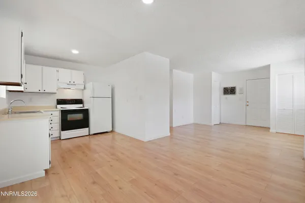 a kitchen with granite countertop white cabinets and stainless steel appliances