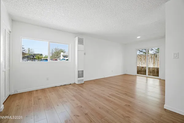 a view of empty room with wooden floor and fireplace