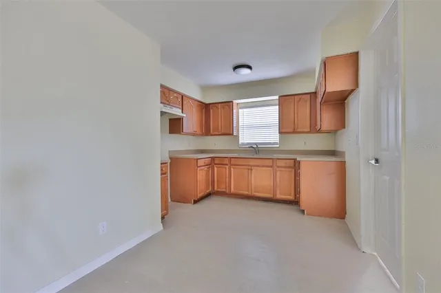 a kitchen with granite countertop cabinets stainless steel appliances a sink and a window