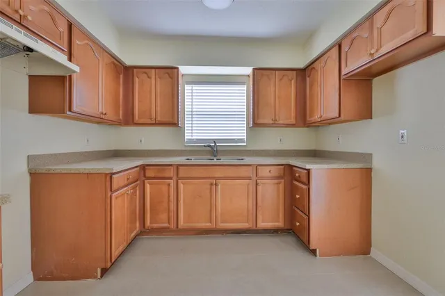 a kitchen with granite countertop wooden cabinets and a sink