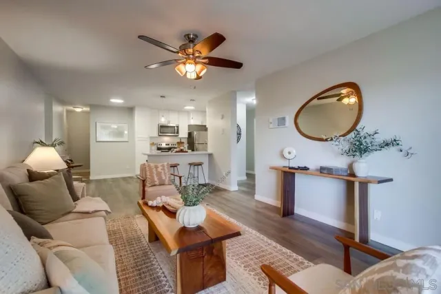a living room with furniture and kitchen chandelier