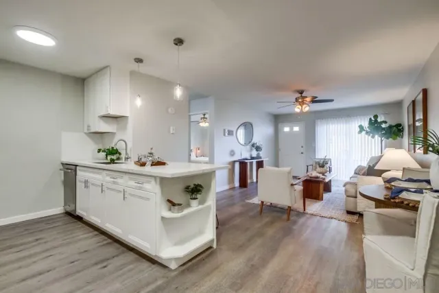 a large white kitchen with cabinets a sink and appliances