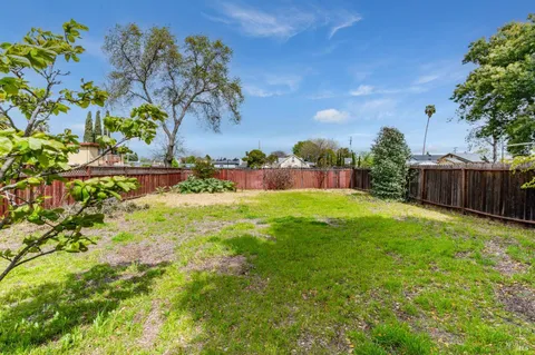 a view of a house with backyard and a tree