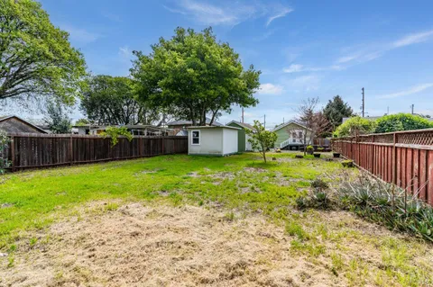 a view of a house with backyard and tree