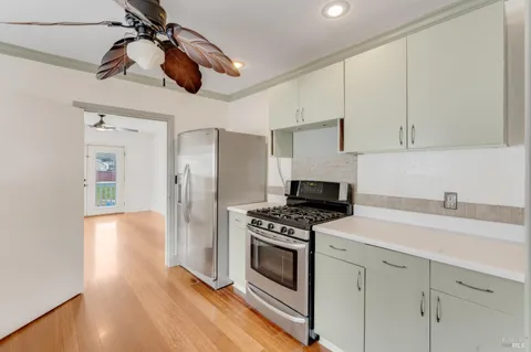a kitchen with stainless steel appliances a stove a refrigerator and cabinets