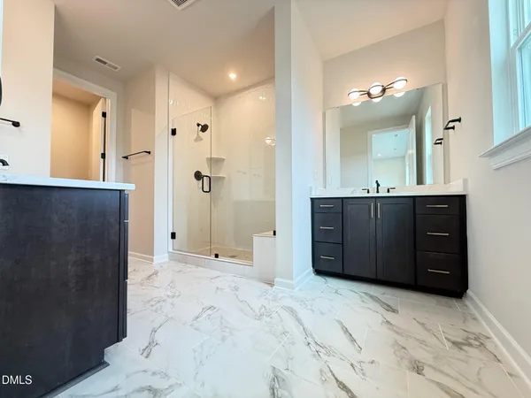 a bathroom with a granite countertop sink a mirror and a shower