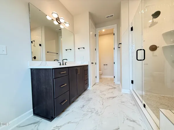 a bathroom with a double vanity sink mirror and shower