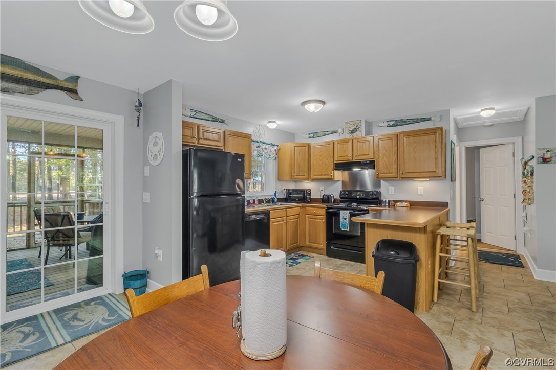 79 Lucom Point Drive Reedville, VA 22539 - Photo 28 of 32 a kitchen with stainless steel appliances granite countertop a refrigerator a sink a stove and a wooden cabinets