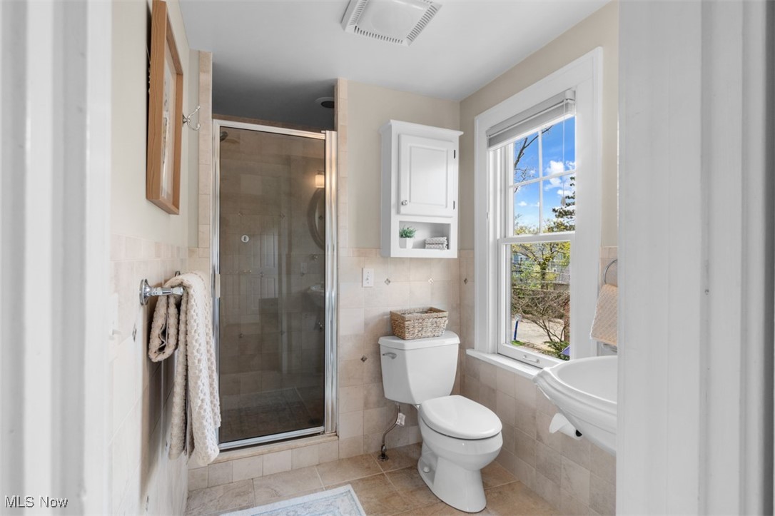 3124 Warrington Road Cleveland, OH 44120 - Photo 20 of 36 Full bath featuring a shower stall, tile patterned floors, tile walls, toilet, and visible vents