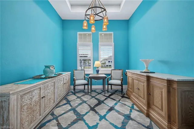a dining room with furniture a chandelier and wooden floor