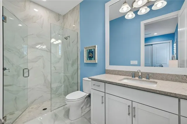 a bathroom with a granite countertop sink a toilet and shower