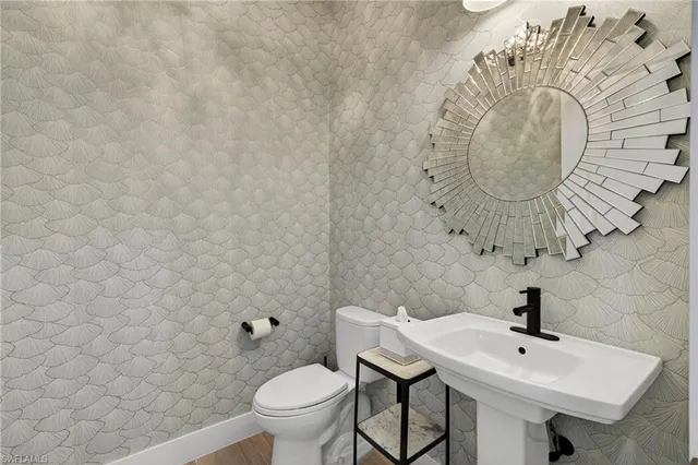 a bathroom with a sink a toilet and mirror