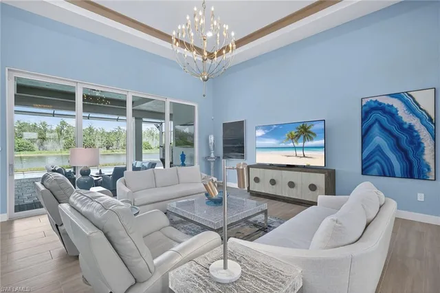 a living room with furniture a chandelier and a flat screen tv