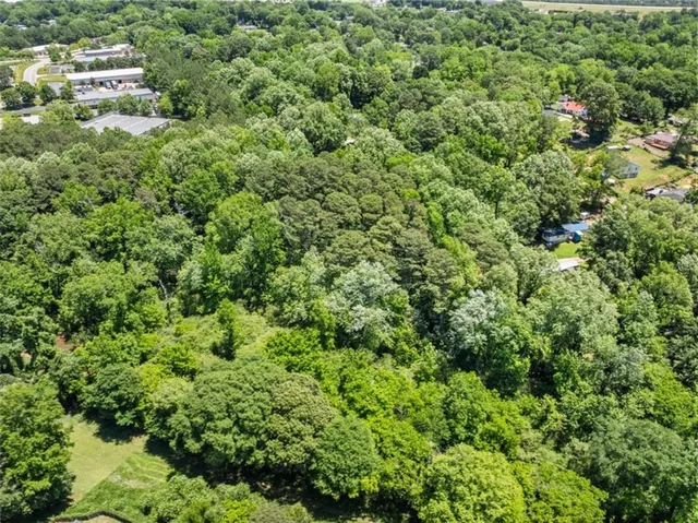 an aerial view of residential houses with outdoor space and trees