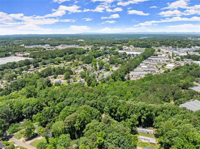 an aerial view of residential houses with outdoor space and trees