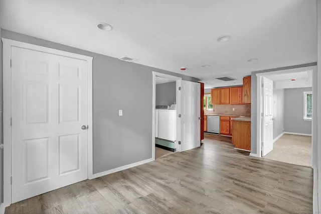 a view of a kitchen with wooden floor and a refrigerator