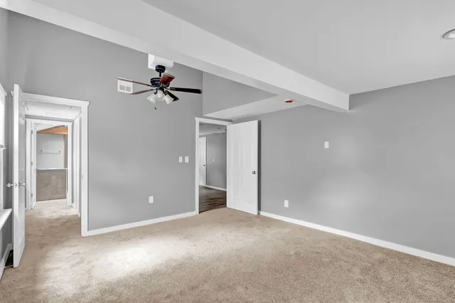 a view of a big room with closet and a ceiling fan