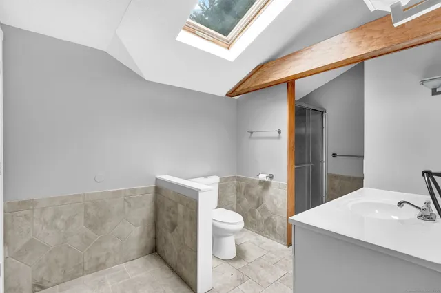 a bathroom with a sink a toilet and a mirror
