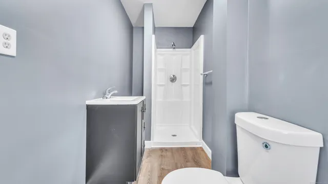 a bathroom with a sink a toilet and shower