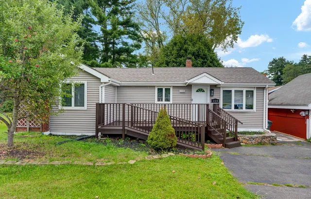 a view of a house with a yard chairs and a patio