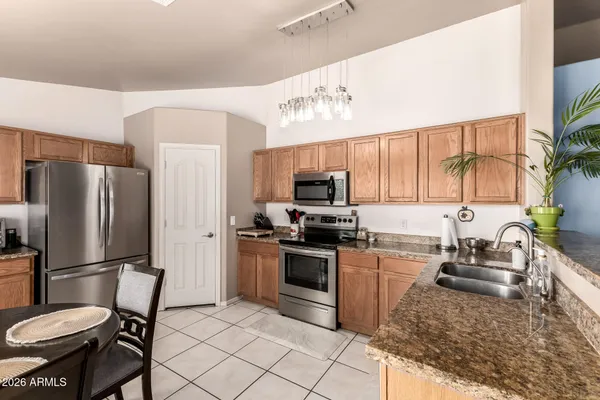 a kitchen with stainless steel appliances granite countertop a refrigerator stove and sink