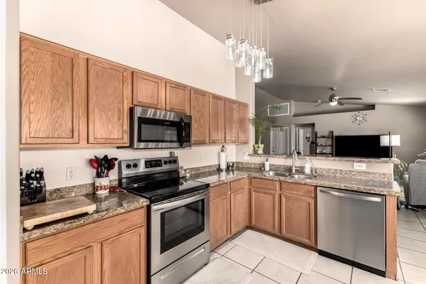 a kitchen with stainless steel appliances a sink dishwasher stove top oven and cabinets with wooden floor
