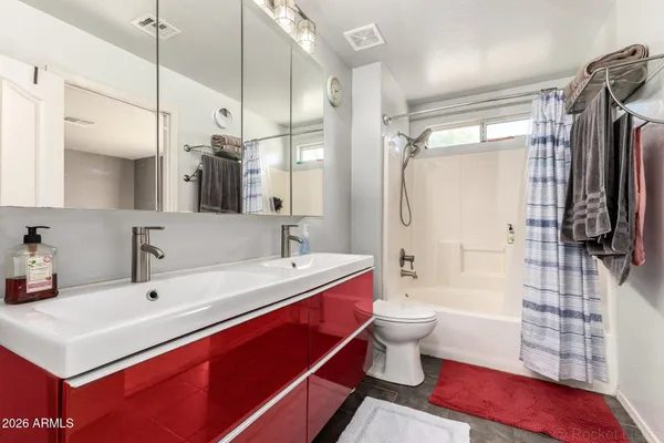 a bathroom with a sink a toilet and shower