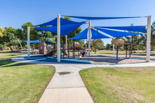a view of swimming pool with lawn chairs under an umbrella