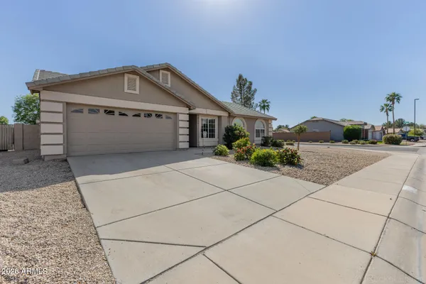 a view of a house with a bench and potted plants