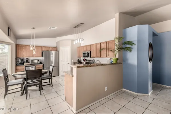 a kitchen with stainless steel appliances kitchen island granite countertop refrigerator and cabinets