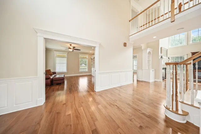 a view of a hallway view with living room and wooden floor