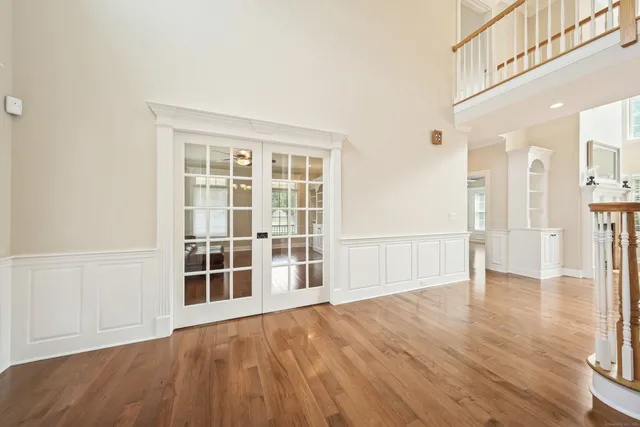 a view of empty room with wooden floor and floor to ceiling window