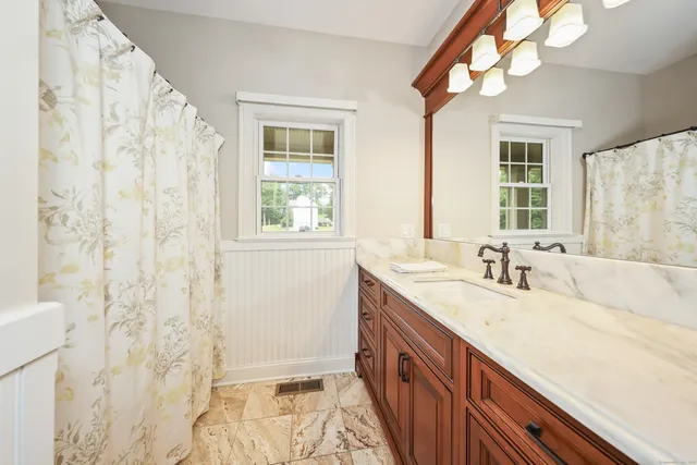 a bathroom with a granite countertop sink a large mirror and a bathtub