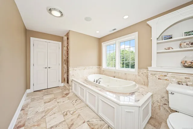 a bathroom with a granite countertop sink and a bathtub