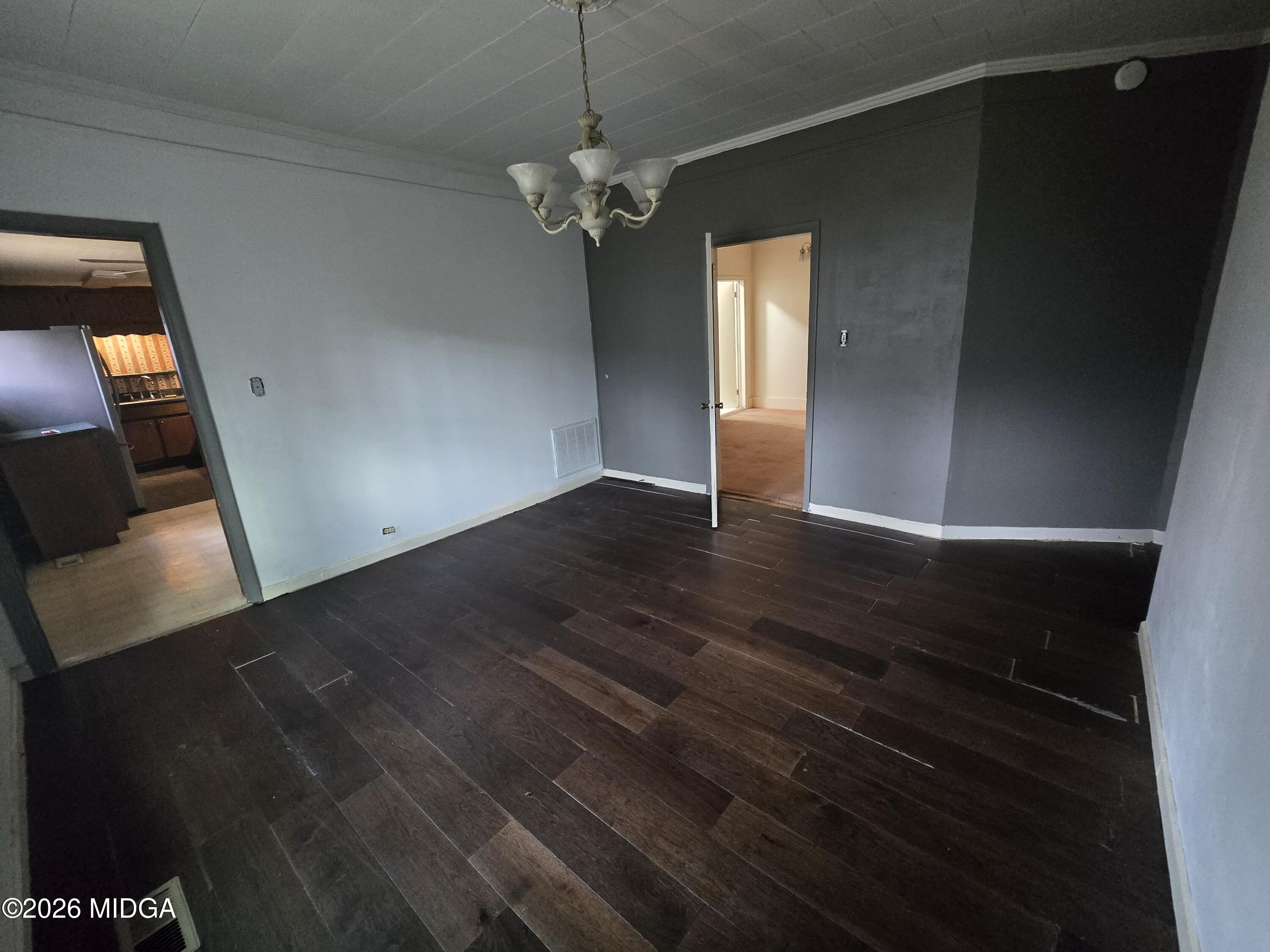1070 Borum Street Unadilla, GA 31091 - Photo 2 of 18 a view of an empty room with wooden floor and a window