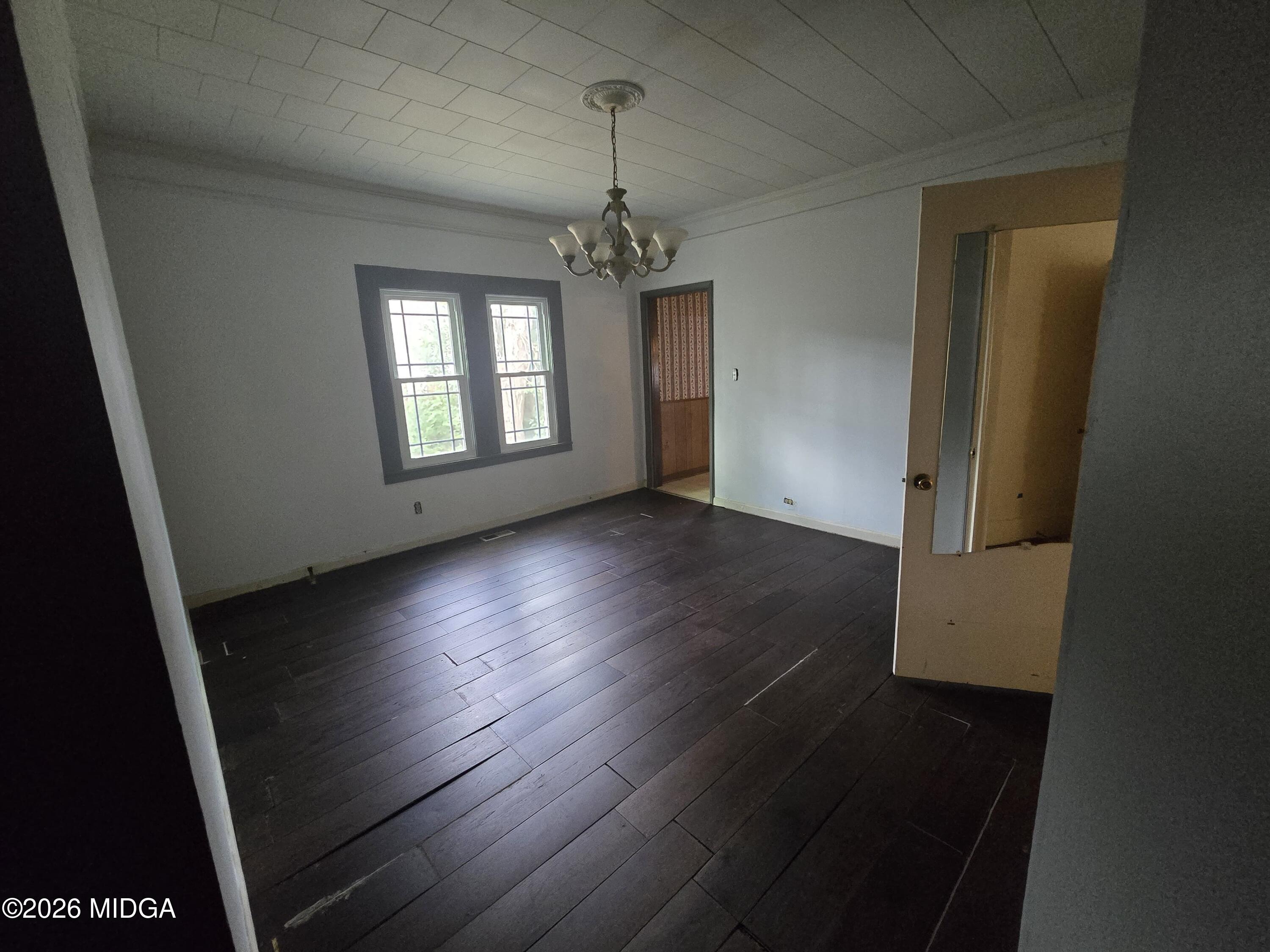 1070 Borum Street Unadilla, GA 31091 - Photo 3 of 18 an empty room with wooden floor and windows