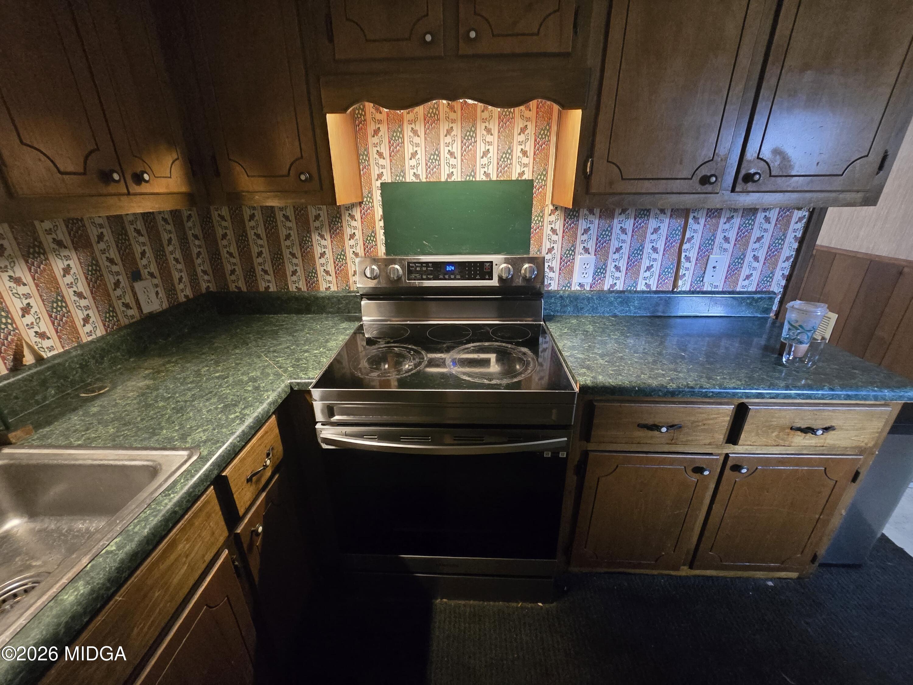 1070 Borum Street Unadilla, GA 31091 - Photo 9 of 18 a kitchen with a stove and a sink