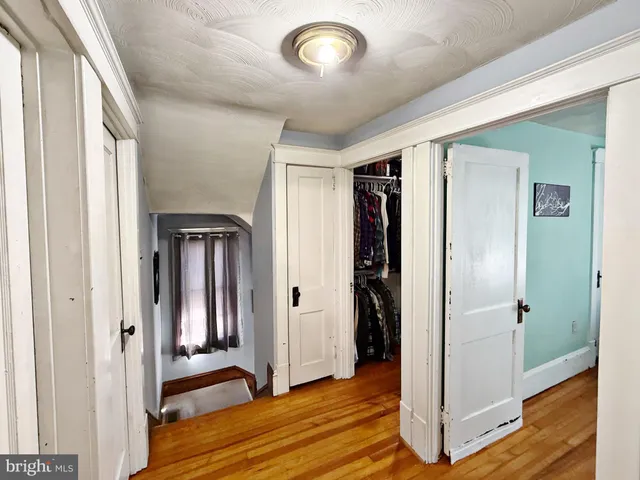 a view of a hallway with wooden floor and entryway