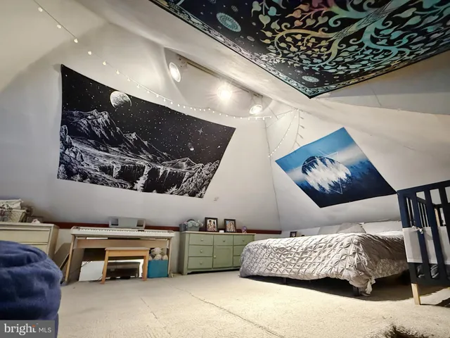 a bedroom with furniture and a painting on the wall