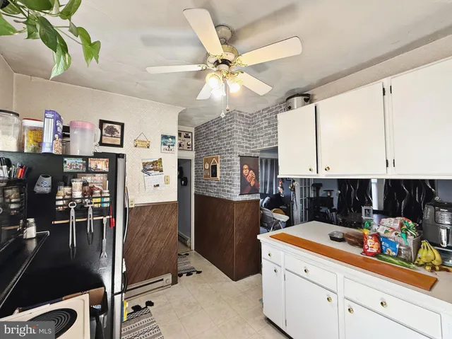 a kitchen with stainless steel appliances kitchen island granite countertop a refrigerator oven a sink a dining table and chairs with wooden floor