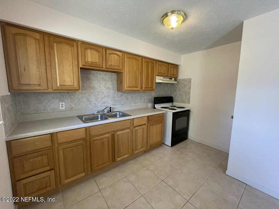 476 Sargo Road Atlantic Beach, FL 32233 - Photo 3 of 8 a kitchen with stainless steel appliances granite countertop a stove a sink and a refrigerator