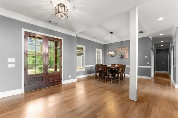 a kitchen with stainless steel appliances granite countertop a stove a refrigerator a sink a oven and a dining table with wooden floor