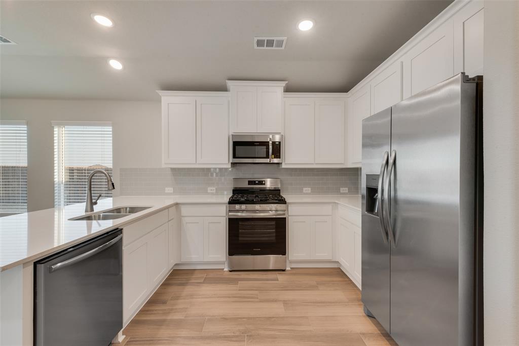 236 Sutter Mill Road Saginaw, TX 76131 - Photo 7 of 20 a kitchen with a sink stove and refrigerator