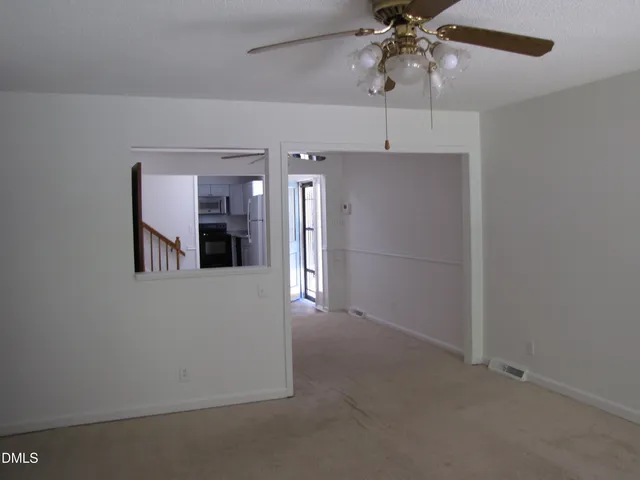 a view of a hallway with a chandelier fan and windows