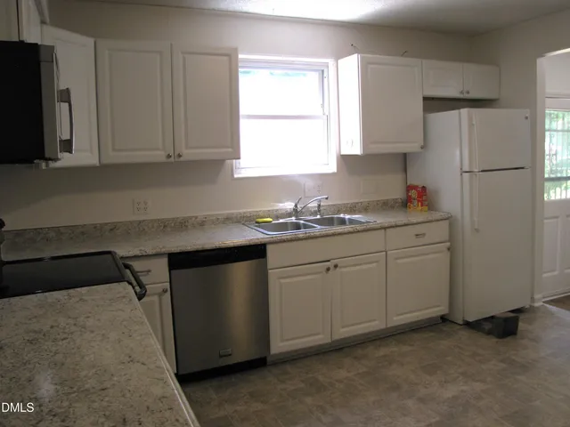 a kitchen with a sink appliances and cabinets