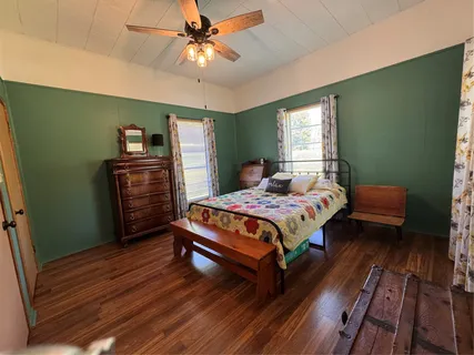 a bedroom with a bed dresser and a window